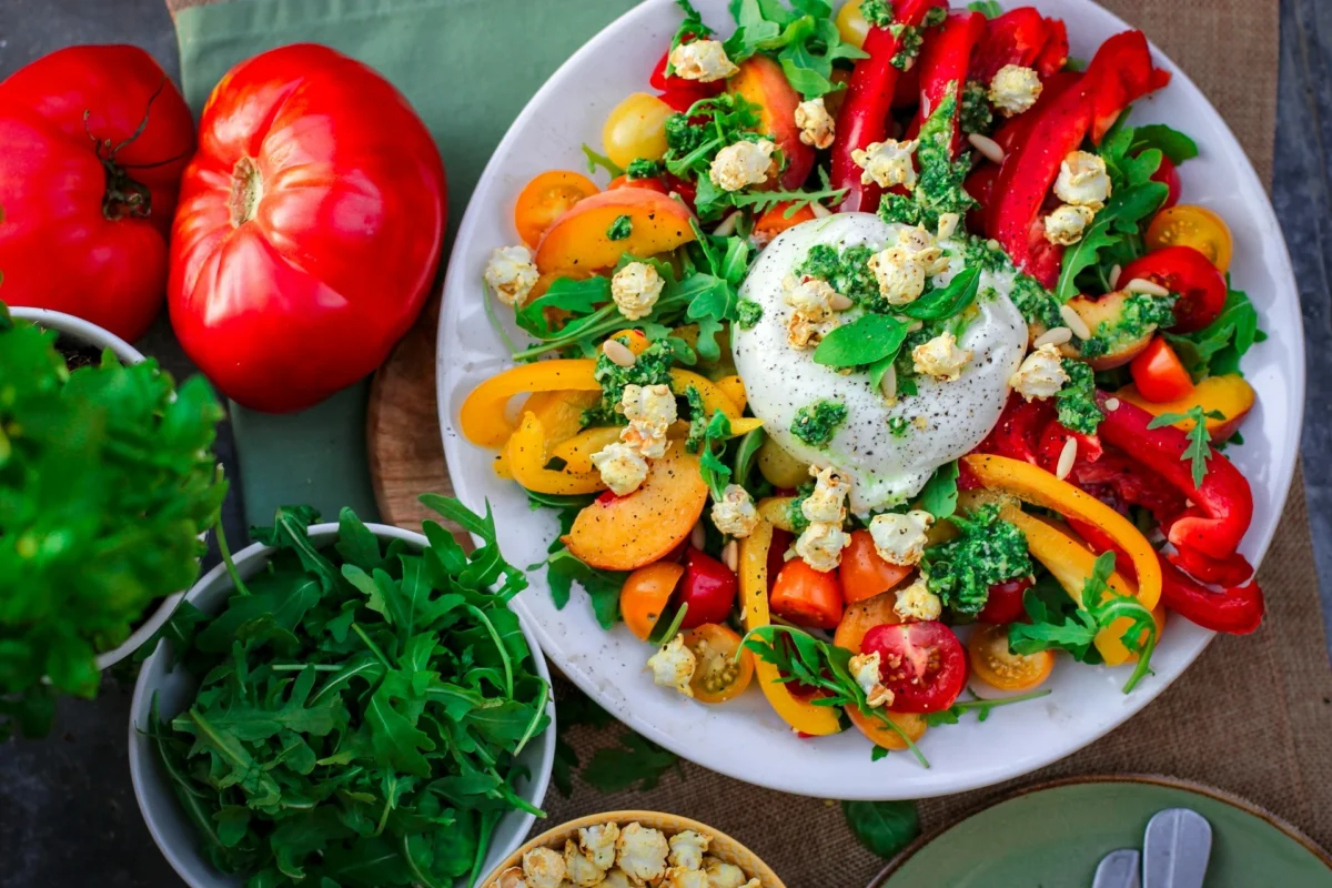 A top-down view of a healthy plate featuring a balanced meal with colorful vegetables, whole grains, lean protein, and healthy fats, arranged neatly on a plate.