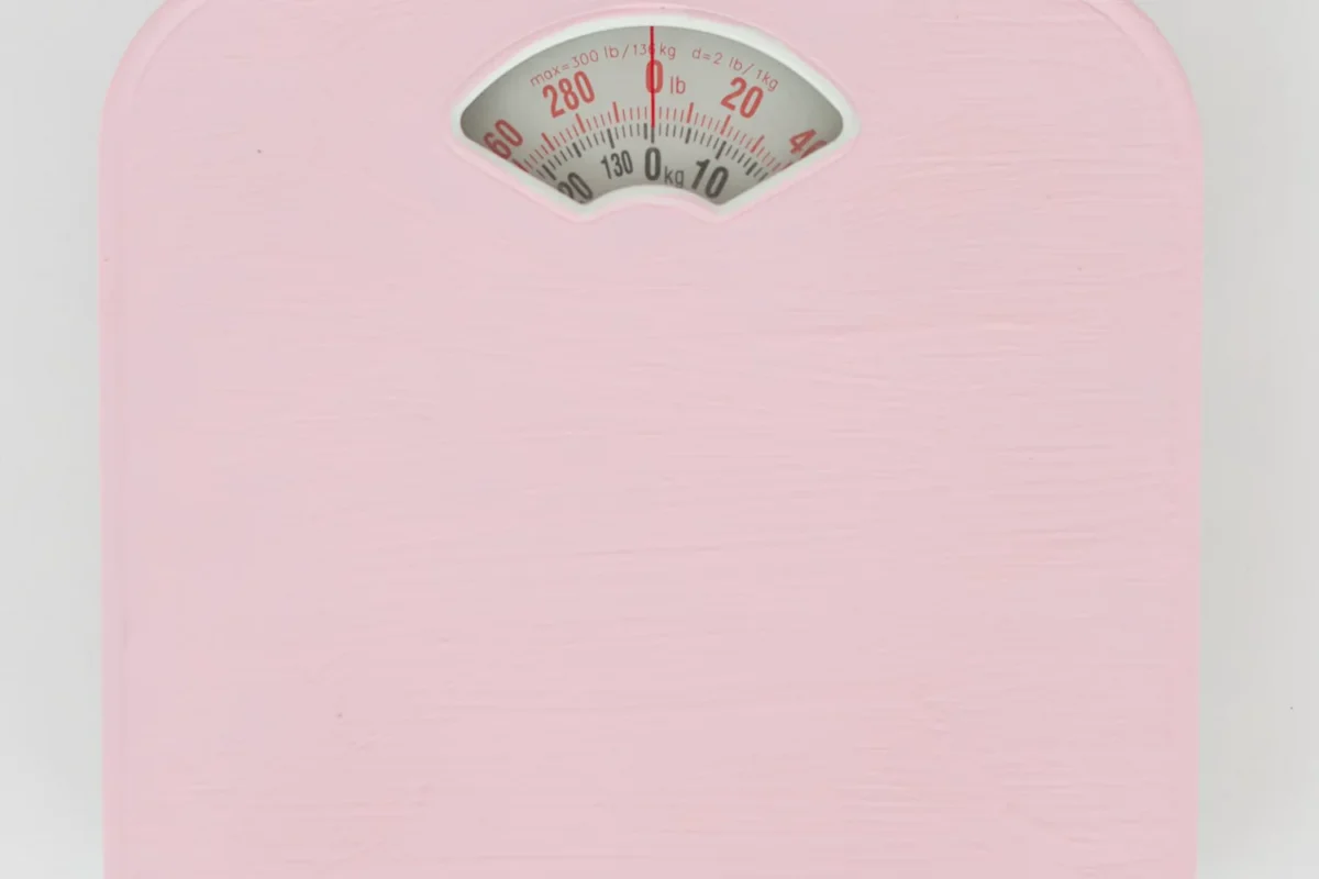 Pink bathroom scale viewed from above on a clean pale background