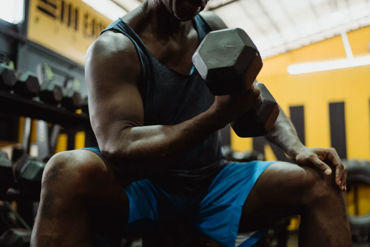 Man performing a dumbbell curl during a gym strength workout